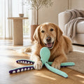 Cane che gioca con il polpo peluche sonoro in casa