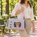 Donna porta a tracolla la borsa trasportino con un cane di piccola taglia durante una passeggiata al parco