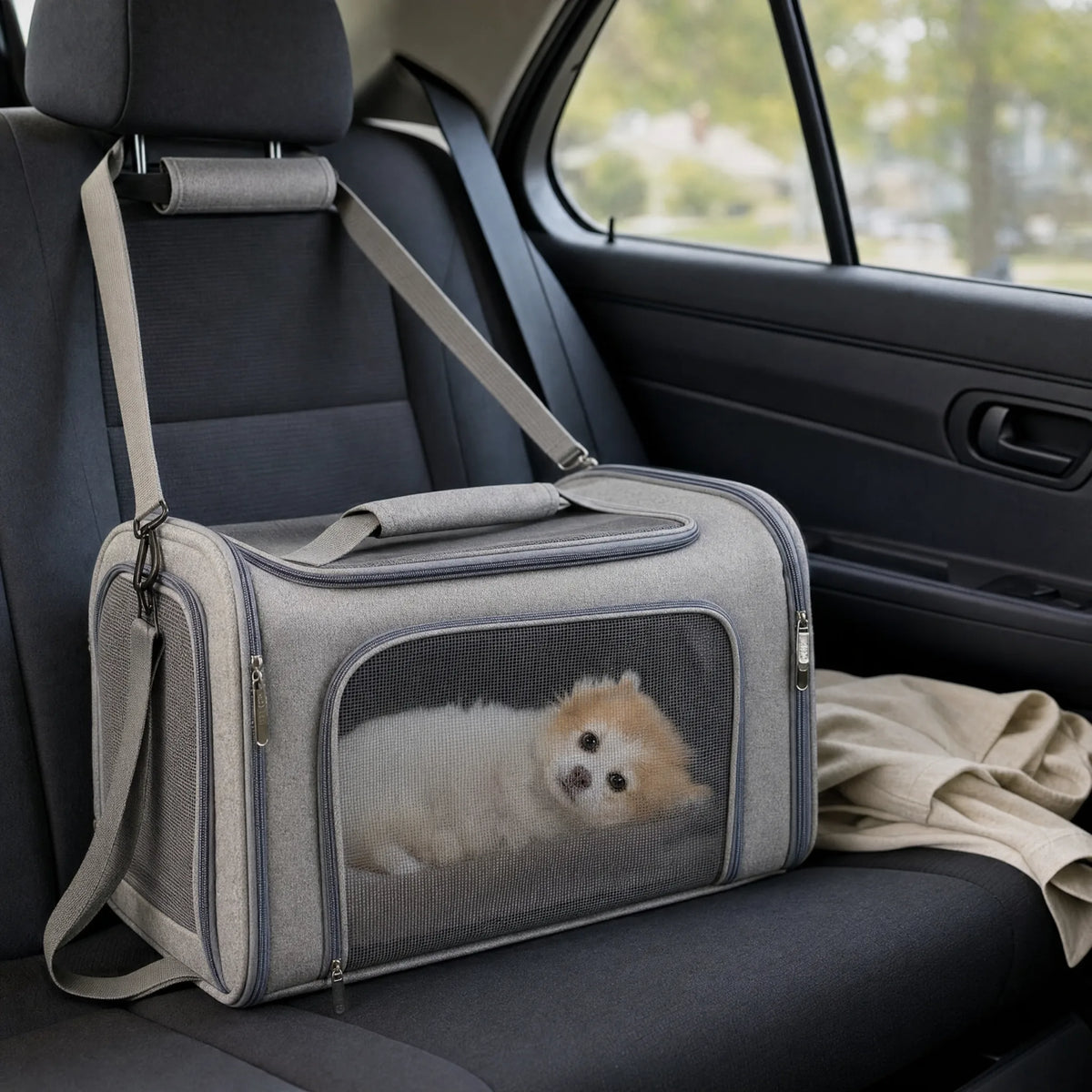 Borsa da trasporto per cani agganciata al sedile posteriore dell'auto con un cane dentro
