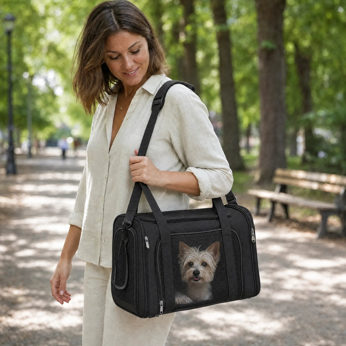 Donna in passeggiata al parco con la borsa da trasporto per cani in tessuto nero