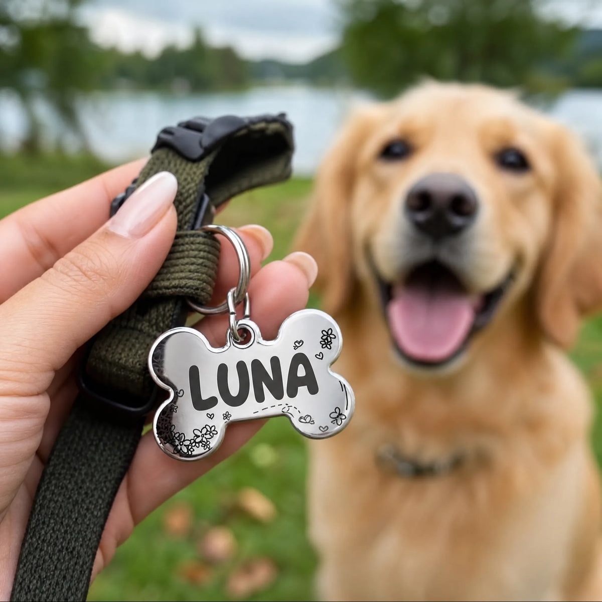 Medaglietta cane personalizzata a osso con nome inciso tenuta in mano al parco