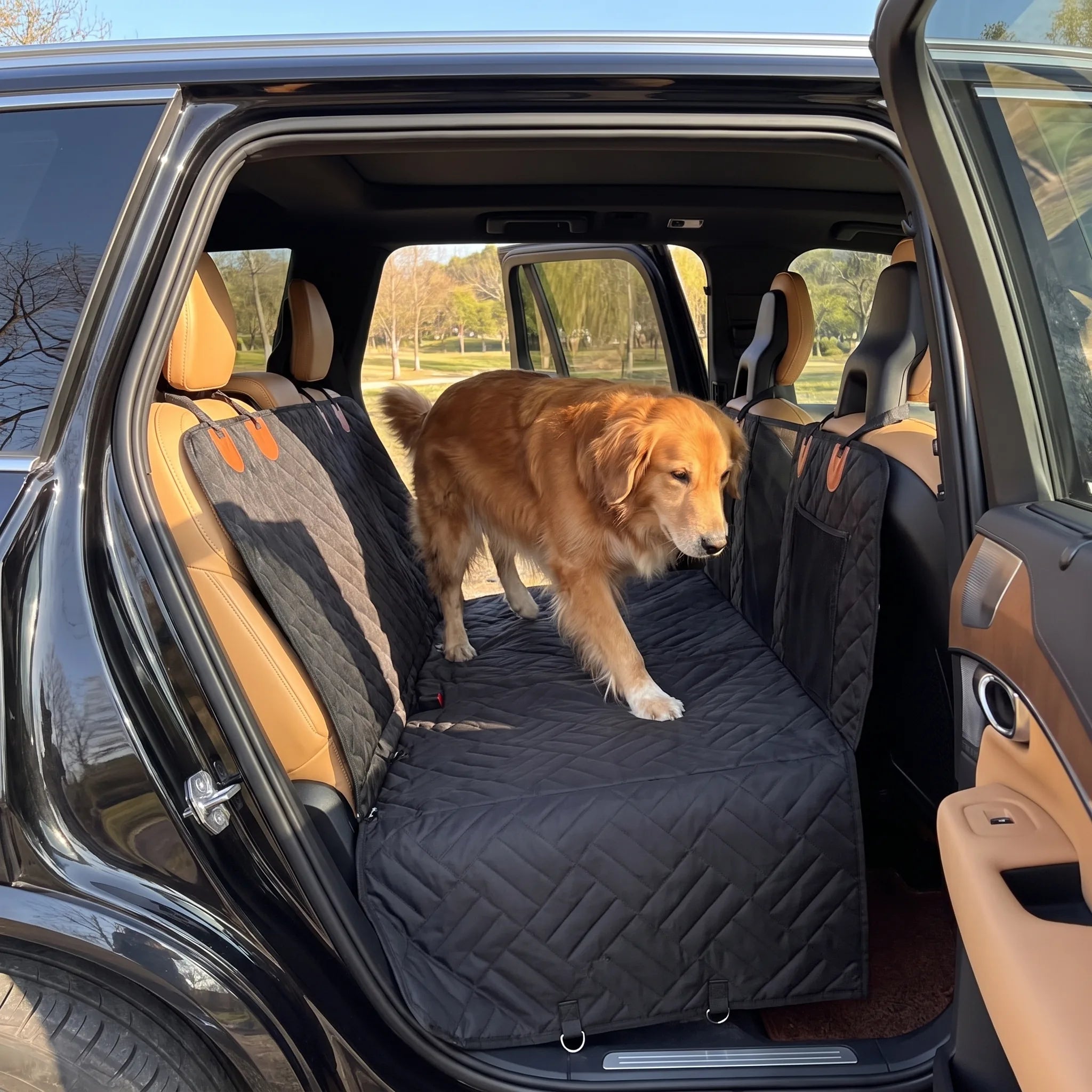 Golden retriever che sale sul sedile posteriore protetto dal coprisedile auto Kit Viaggio Sicuro, portiera aperta su un parco