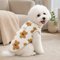 Cane seduto in casa con il pigiama in flanella teddy bianco con orsetti