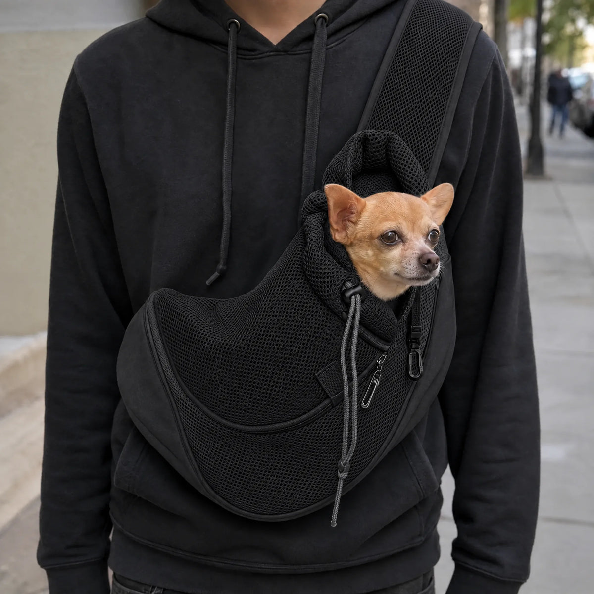 Donna in passeggiata in citta con il cane nel marsupio a tracolla color nero