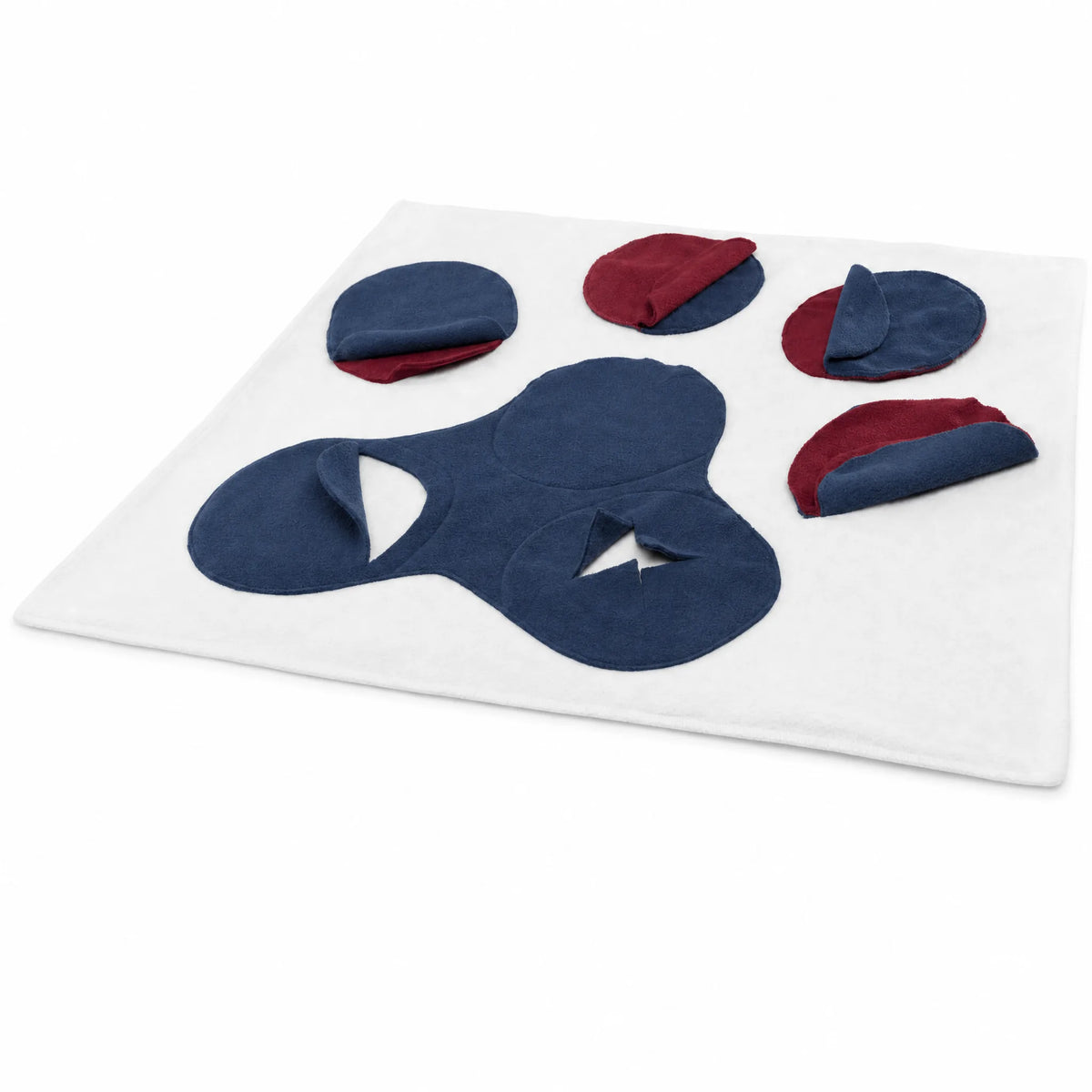 Coperta olfattiva per cani in pile bianco crema con zampa blu navy e tasche bordeaux, vista dall’alto su sfondo bianco